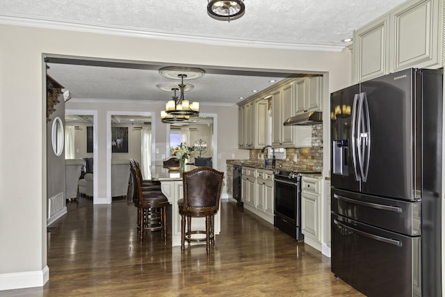 kitchen with electric range, hanging light fixtures, stainless steel refrigerator with ice dispenser, cream cabinets, and a textured ceiling