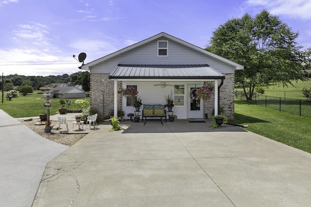 back of property with a lawn and a porch