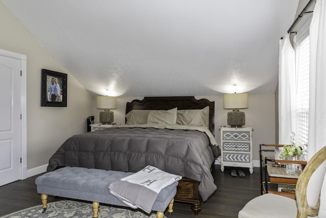 bedroom with dark wood-type flooring and vaulted ceiling