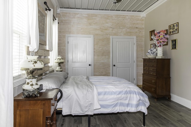 bedroom featuring a barn door, crown molding, and dark hardwood / wood-style flooring