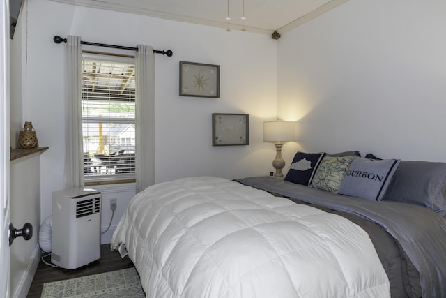 bedroom with dark hardwood / wood-style flooring and ornamental molding