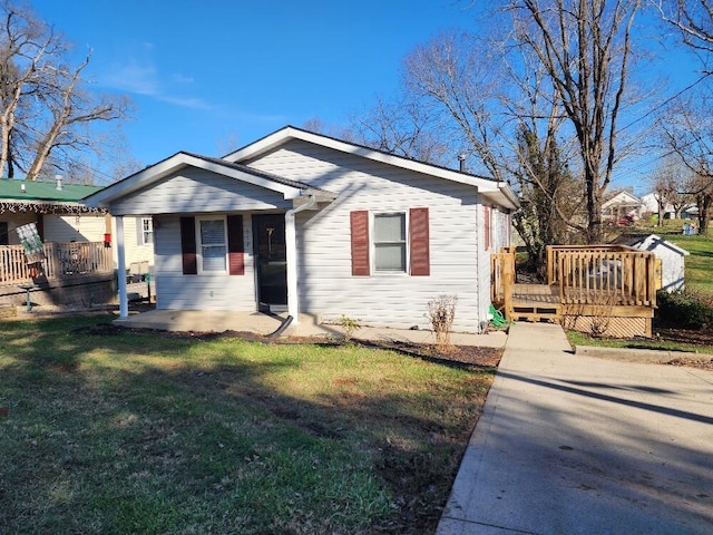 view of front facade with covered porch, a deck, and a front lawn