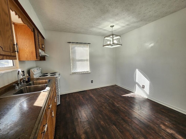 kitchen with a textured ceiling, dark wood-type flooring, sink, pendant lighting, and range