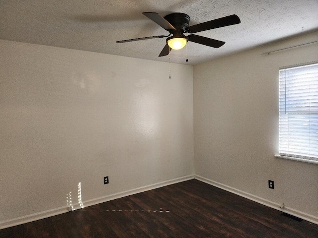 empty room featuring a textured ceiling, dark hardwood / wood-style floors, and ceiling fan