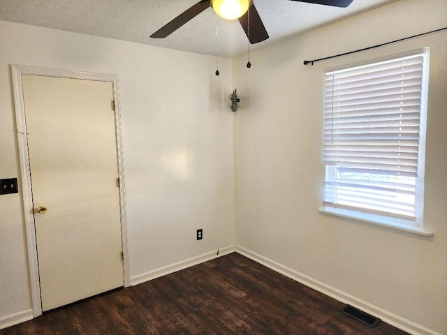 spare room with a textured ceiling, dark hardwood / wood-style floors, and ceiling fan