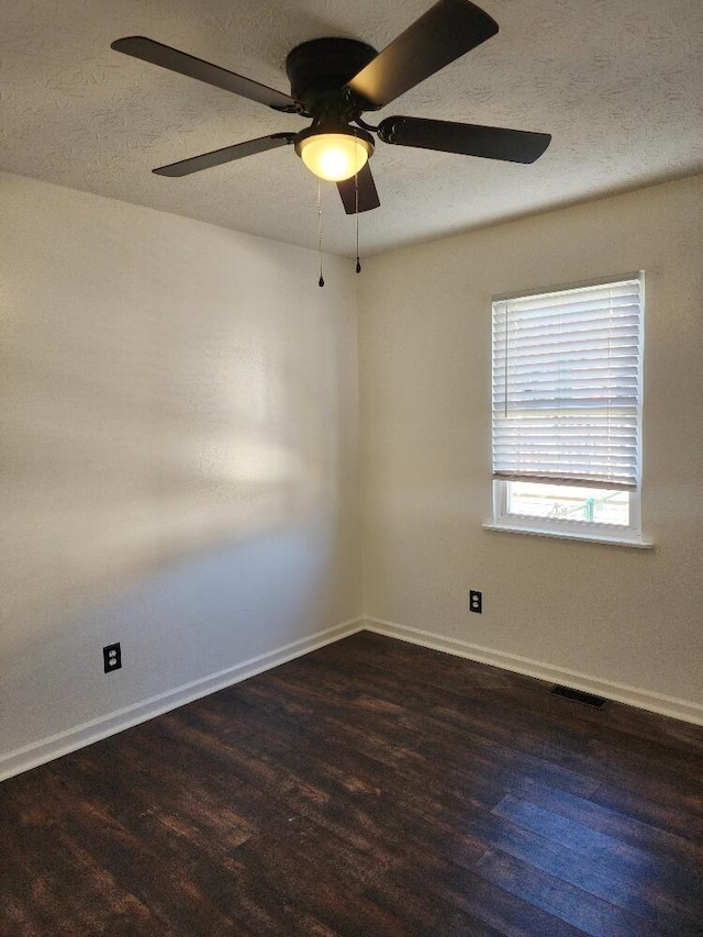 spare room with dark hardwood / wood-style flooring and ceiling fan