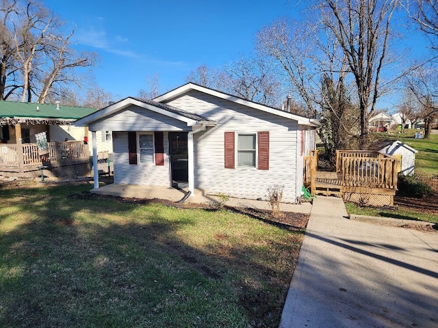 view of front of home featuring a front lawn and a wooden deck