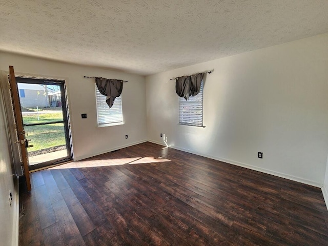 spare room featuring dark hardwood / wood-style flooring and a textured ceiling