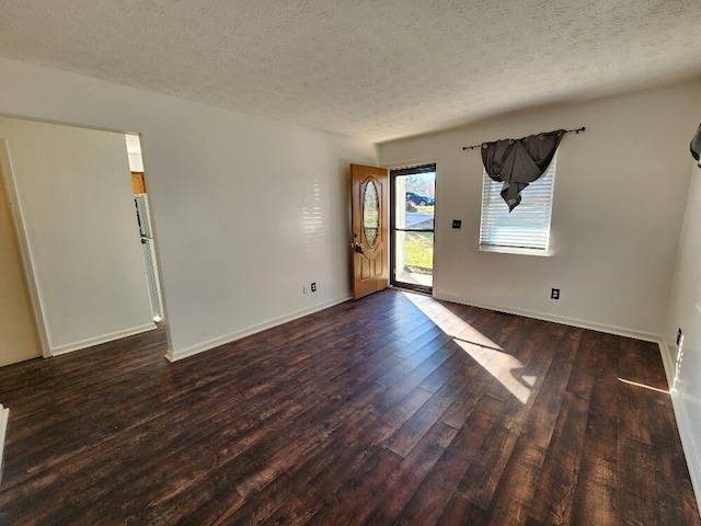 empty room featuring dark hardwood / wood-style flooring and a textured ceiling