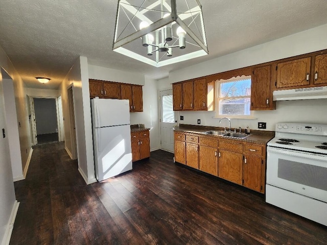 kitchen with white appliances, sink, dark hardwood / wood-style floors, a textured ceiling, and a notable chandelier