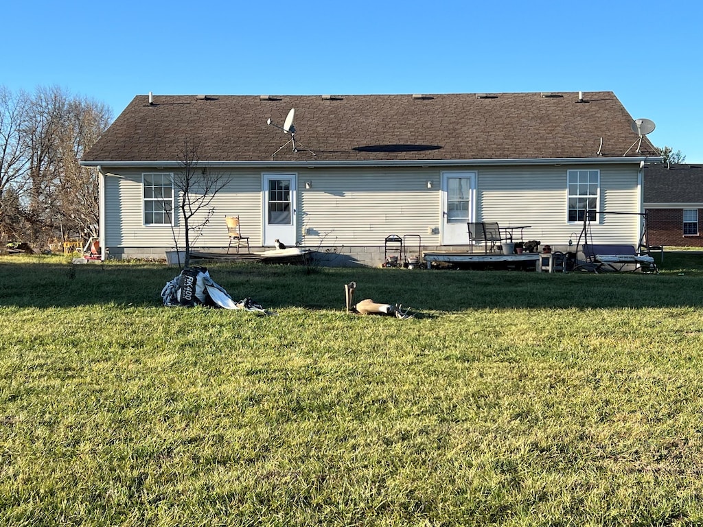 rear view of property featuring a yard