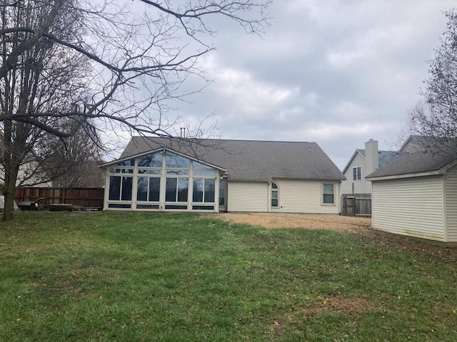 back of house with a lawn and a sunroom