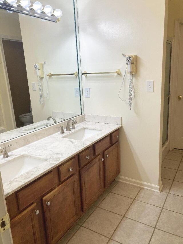 bathroom with tile patterned floors, walk in shower, vanity, and toilet