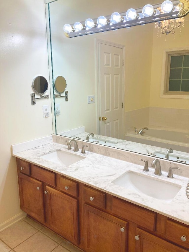 bathroom featuring tile patterned floors, a bathtub, vanity, and a chandelier