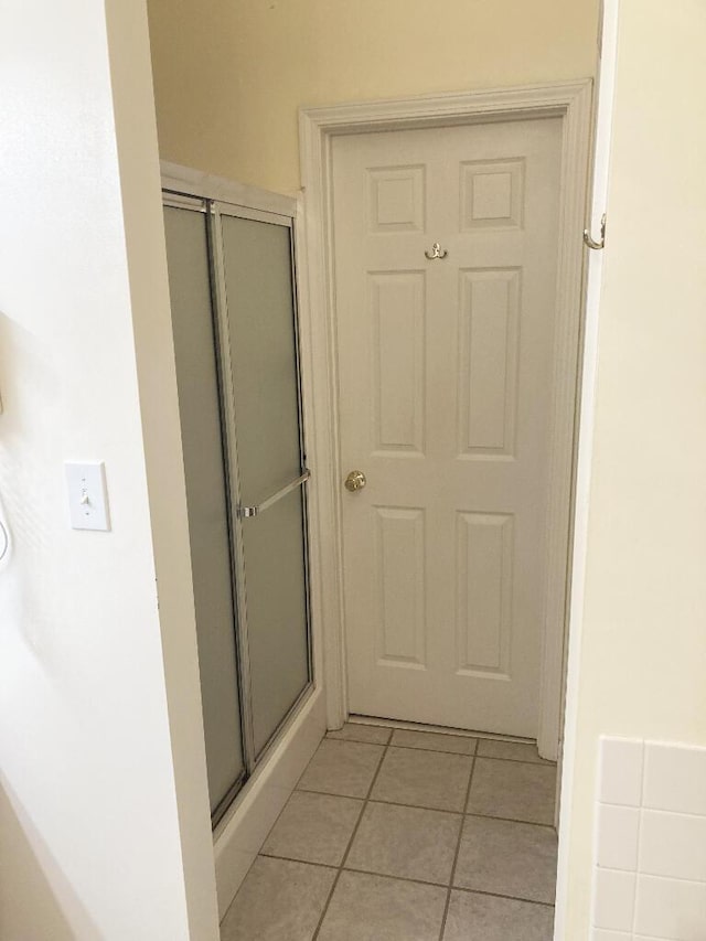 bathroom featuring tile patterned flooring and a shower with shower door