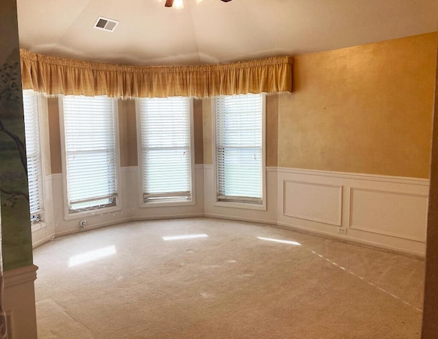 unfurnished dining area featuring light colored carpet, ceiling fan, and lofted ceiling