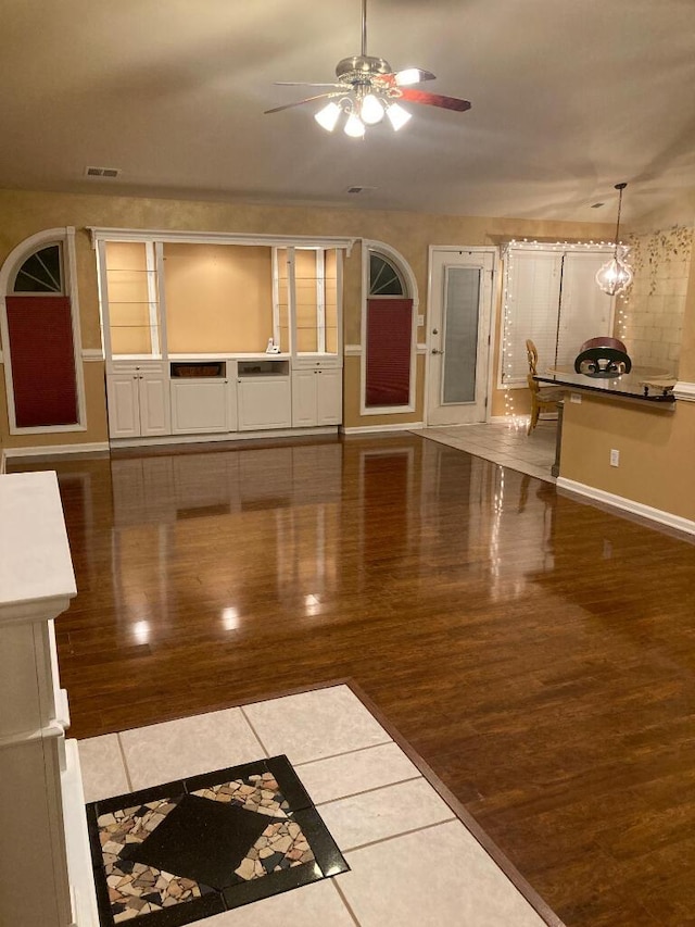 unfurnished living room with ceiling fan and tile patterned flooring