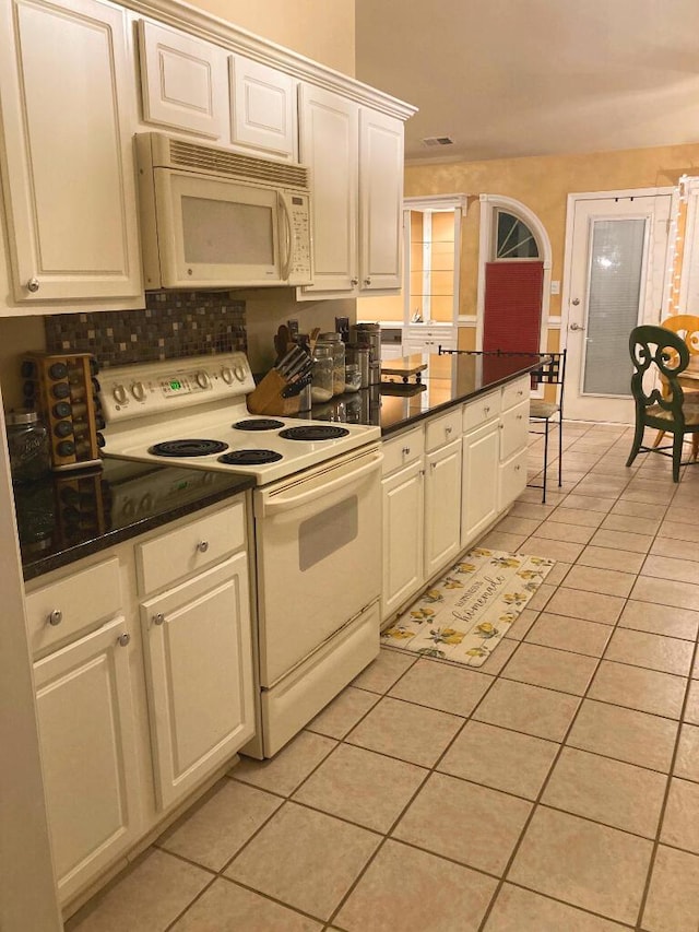 kitchen featuring white appliances, white cabinetry, and light tile patterned flooring