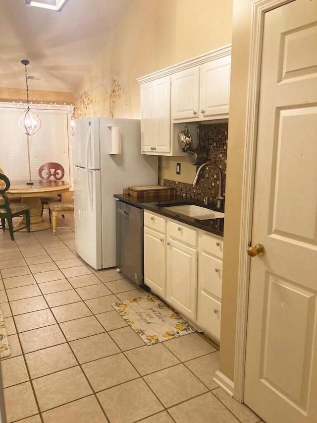 kitchen featuring sink, white cabinets, stainless steel dishwasher, and light tile patterned floors