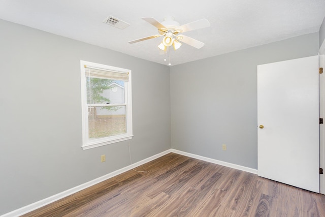 empty room with visible vents, ceiling fan, baseboards, and wood finished floors