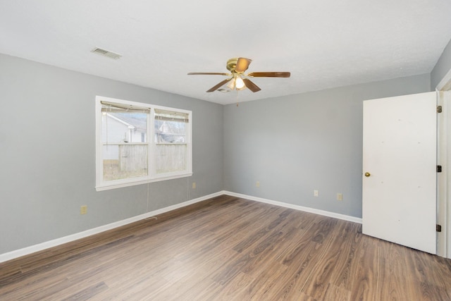 spare room featuring visible vents, baseboards, ceiling fan, and wood finished floors