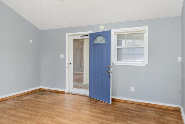 entrance foyer with baseboards, a textured ceiling, and light wood finished floors