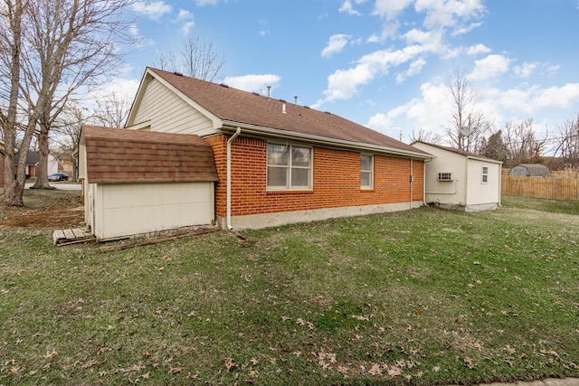 view of side of home featuring brick siding, a lawn, and roof with shingles