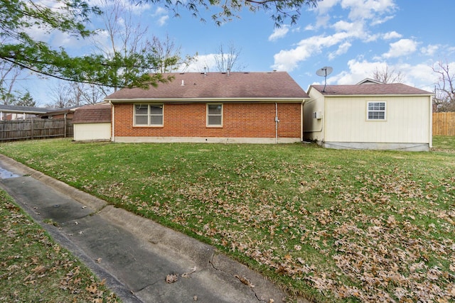 back of property featuring brick siding, a lawn, and fence