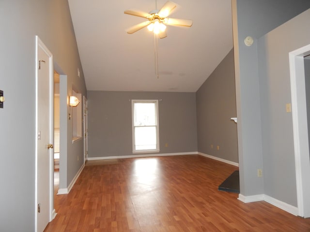 additional living space with lofted ceiling, wood finished floors, a ceiling fan, and baseboards