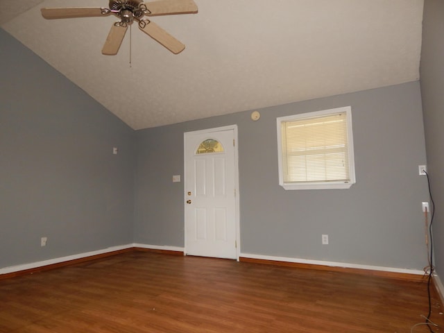 spare room featuring a ceiling fan, baseboards, vaulted ceiling, and wood finished floors