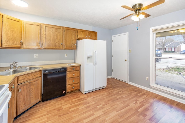 kitchen featuring white refrigerator with ice dispenser, stove, light wood-style floors, a sink, and dishwasher