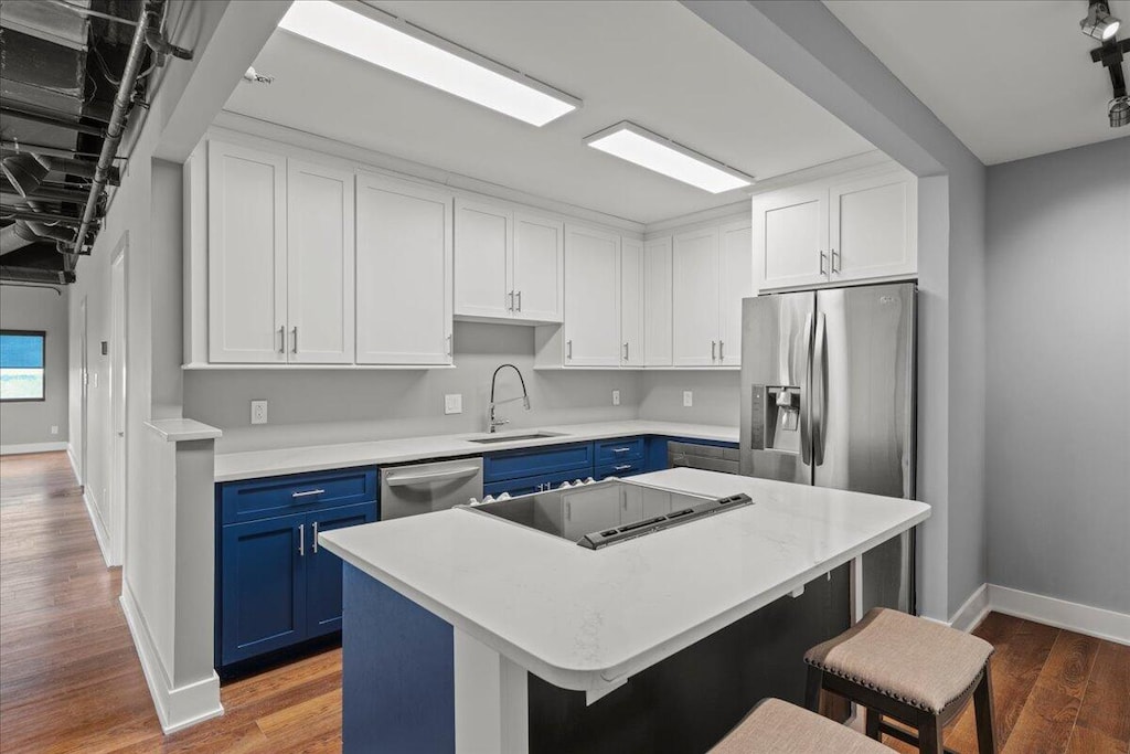 kitchen featuring blue cabinetry, a center island, stainless steel appliances, and sink