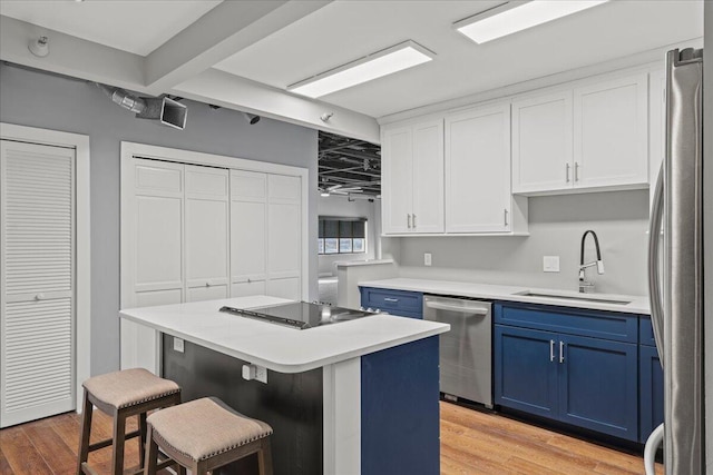 kitchen featuring blue cabinetry, sink, a kitchen island, and stainless steel appliances