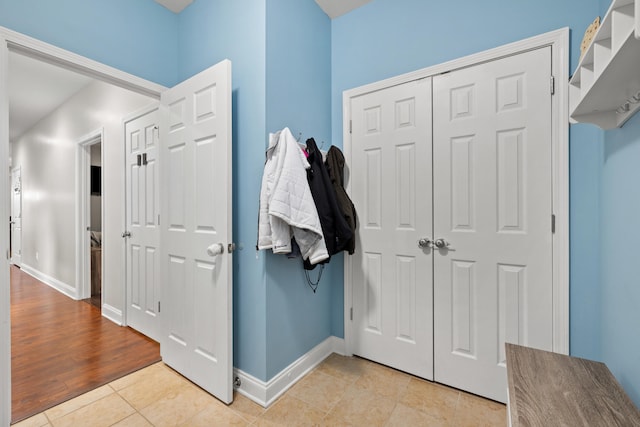 foyer entrance featuring baseboards and light tile patterned floors