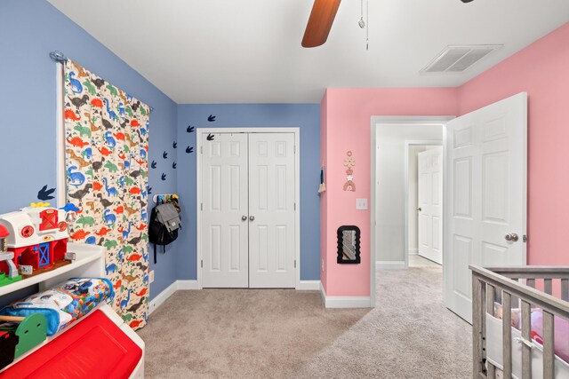 carpeted bedroom with ceiling fan, a closet, visible vents, and baseboards