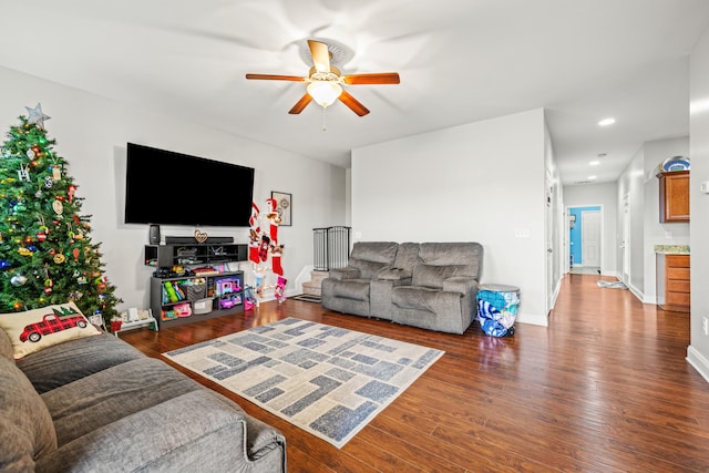 living room with ceiling fan and dark wood-type flooring