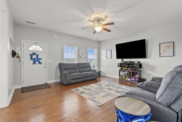 living room featuring baseboards, ceiling fan, visible vents, and wood finished floors