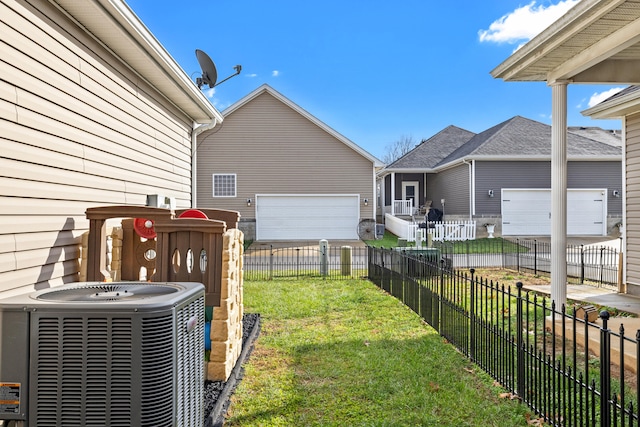 view of yard featuring central air condition unit, fence private yard, and a garage