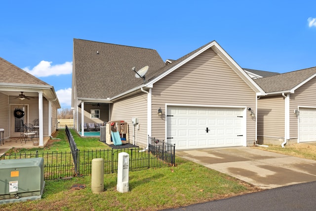 view of front of home featuring an attached garage, a ceiling fan, a front yard, fence, and driveway