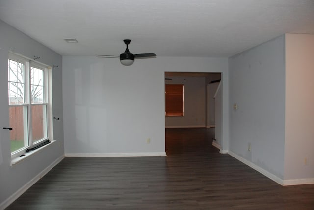 unfurnished room featuring ceiling fan and dark wood-type flooring