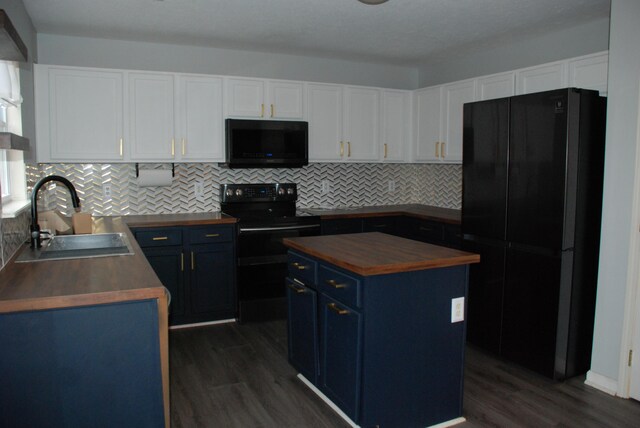 kitchen featuring black appliances, wood counters, blue cabinets, and sink