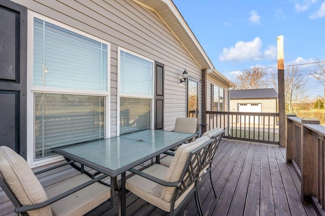 wooden deck with a garage and an outbuilding