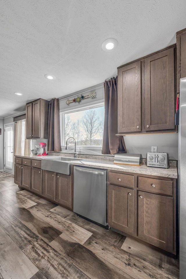 kitchen with dark brown cabinetry, dishwasher, dark wood-type flooring, and sink