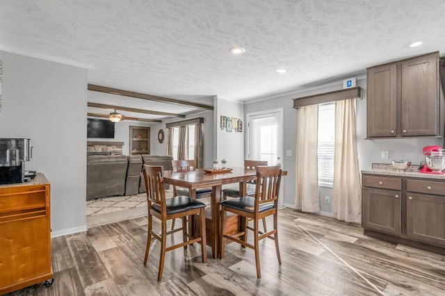 dining space with a textured ceiling, hardwood / wood-style flooring, and a healthy amount of sunlight