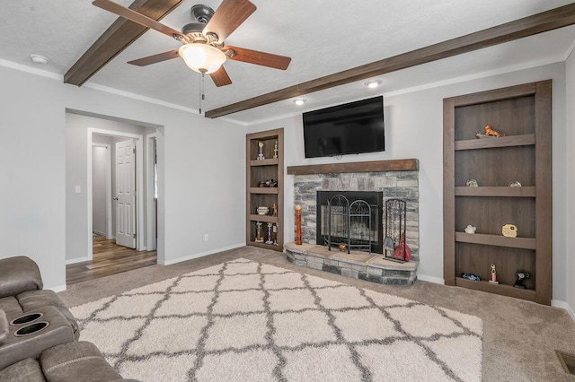 unfurnished living room with built in shelves, ceiling fan, light colored carpet, and a fireplace