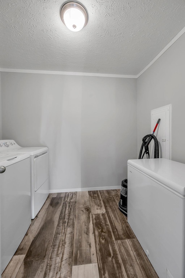 laundry area with a textured ceiling, washing machine and dryer, and dark wood-type flooring