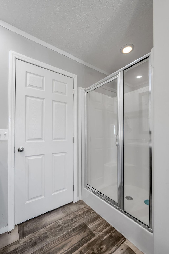 bathroom featuring hardwood / wood-style floors, ornamental molding, and walk in shower