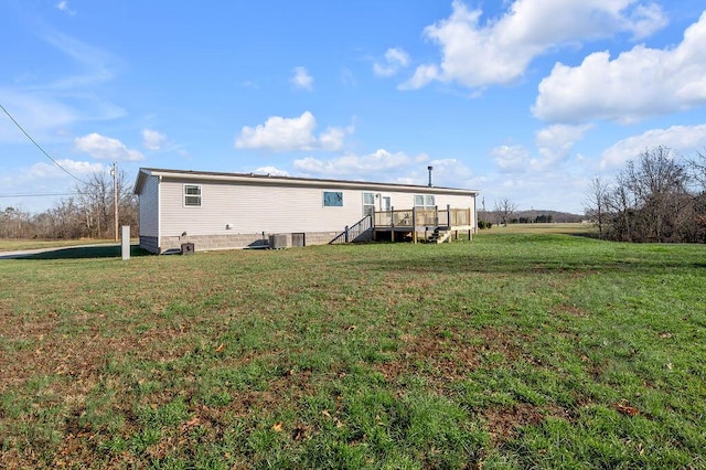 back of house with a yard, central AC unit, and a wooden deck