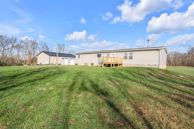 rear view of property with a lawn and a wooden deck