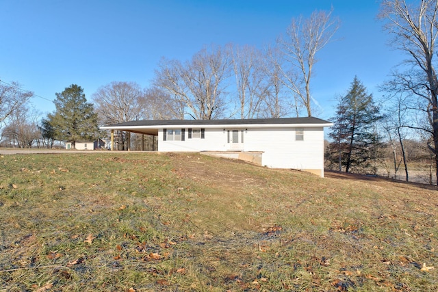 back of property featuring a carport and a yard